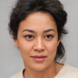 Joyful latino young-adult female with medium  brown hair and brown eyes