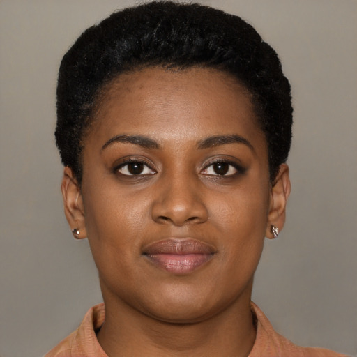Joyful black young-adult female with short  black hair and brown eyes