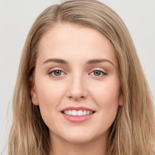 Joyful white young-adult female with long  brown hair and grey eyes