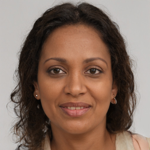 Joyful black adult female with long  brown hair and brown eyes