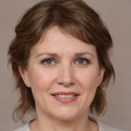 Joyful white adult female with medium  brown hair and grey eyes