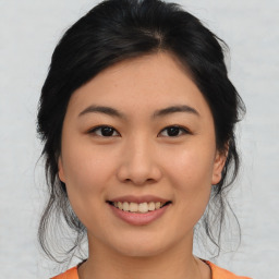 Joyful asian young-adult female with medium  black hair and brown eyes