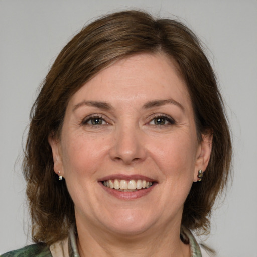 Joyful white adult female with medium  brown hair and green eyes