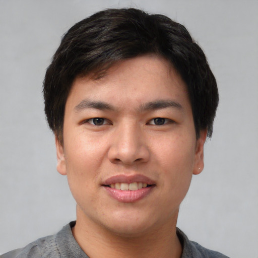 Joyful asian young-adult male with short  black hair and brown eyes