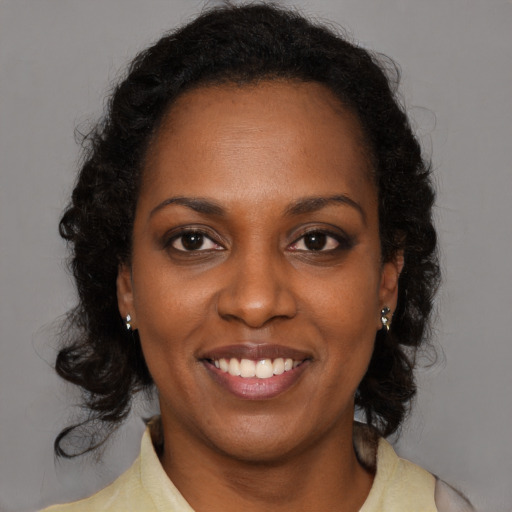 Joyful black young-adult female with medium  brown hair and brown eyes
