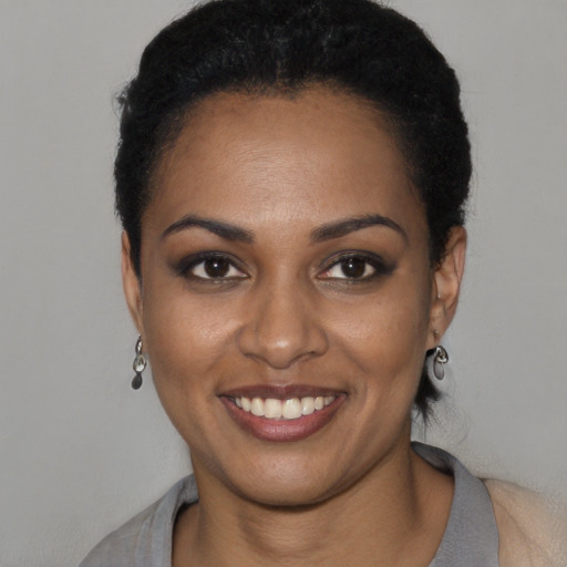 Joyful black young-adult female with short  black hair and brown eyes