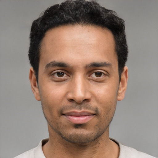 Joyful latino young-adult male with short  black hair and brown eyes