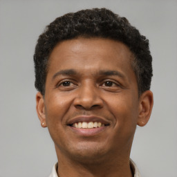 Joyful latino young-adult male with short  brown hair and brown eyes