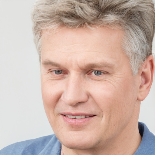 Joyful white adult male with short  brown hair and blue eyes