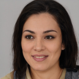 Joyful latino young-adult female with long  brown hair and brown eyes