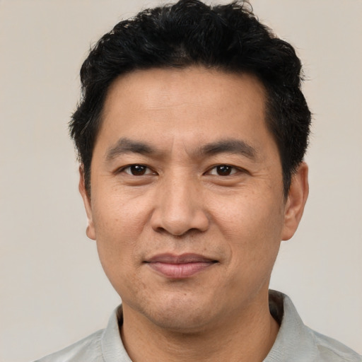 Joyful asian adult male with short  black hair and brown eyes