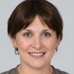 Joyful white adult female with medium  brown hair and grey eyes