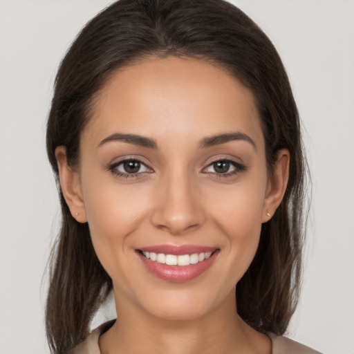 Joyful white young-adult female with long  brown hair and brown eyes