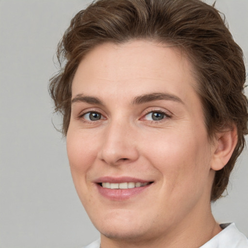 Joyful white young-adult female with short  brown hair and green eyes