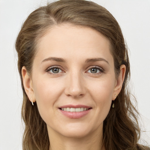 Joyful white young-adult female with long  brown hair and grey eyes