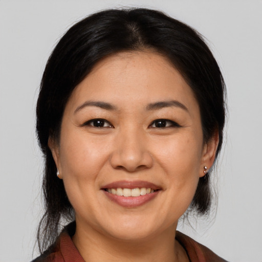 Joyful asian adult female with medium  brown hair and brown eyes