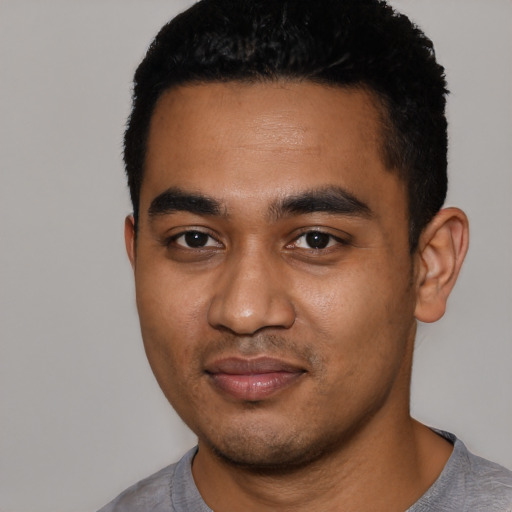 Joyful black young-adult male with short  black hair and brown eyes