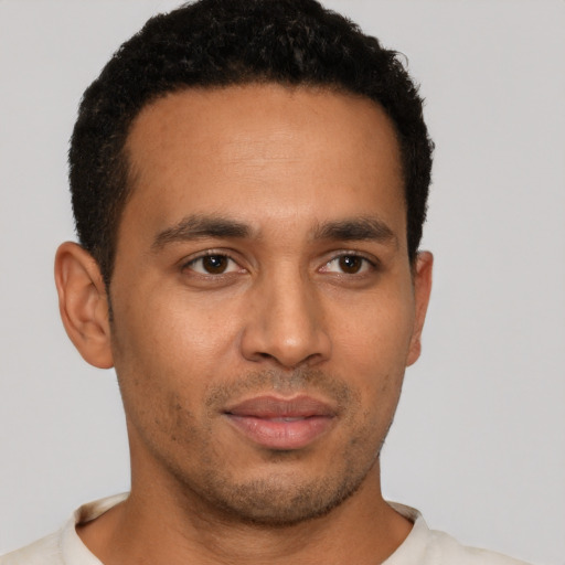 Joyful latino young-adult male with short  brown hair and brown eyes