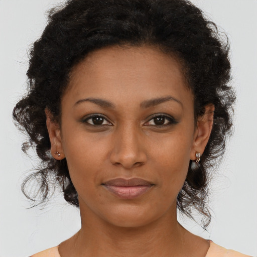 Joyful black young-adult female with medium  brown hair and brown eyes