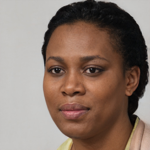 Joyful black young-adult female with short  black hair and brown eyes