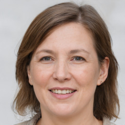 Joyful white adult female with medium  brown hair and grey eyes