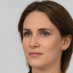 Joyful white adult female with long  brown hair and grey eyes