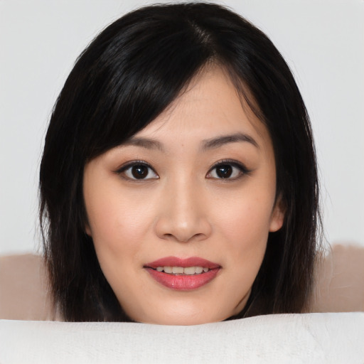 Joyful asian young-adult female with medium  brown hair and brown eyes