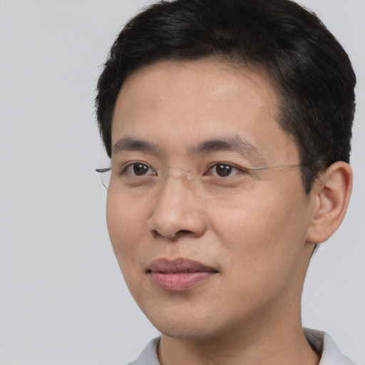Joyful asian young-adult male with short  black hair and brown eyes