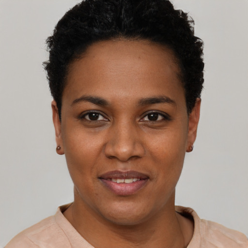 Joyful black young-adult female with short  black hair and brown eyes