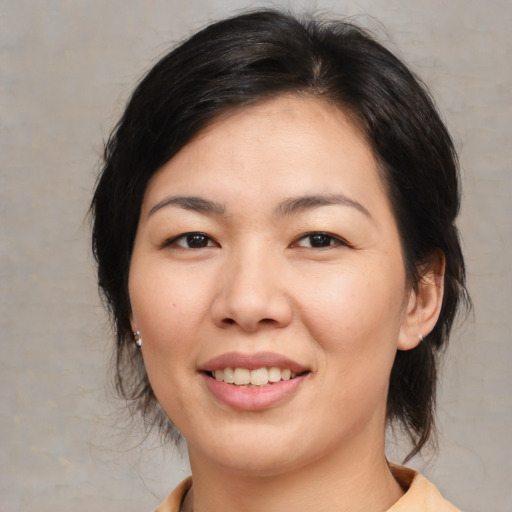 Joyful asian young-adult female with medium  brown hair and brown eyes