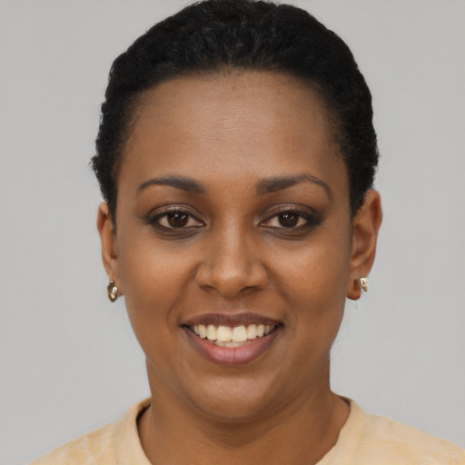 Joyful black young-adult female with short  black hair and brown eyes