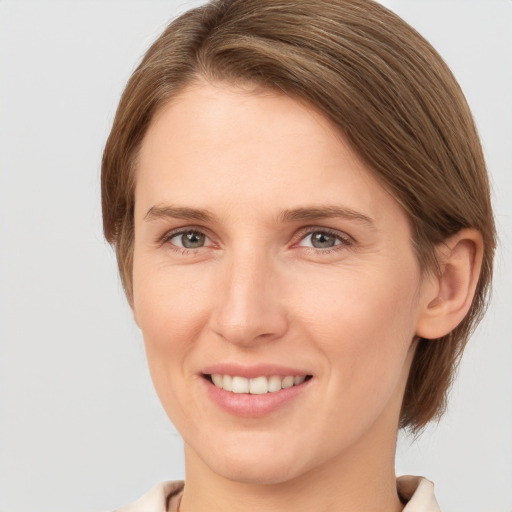 Joyful white young-adult female with medium  brown hair and grey eyes