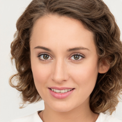 Joyful white young-adult female with medium  brown hair and green eyes