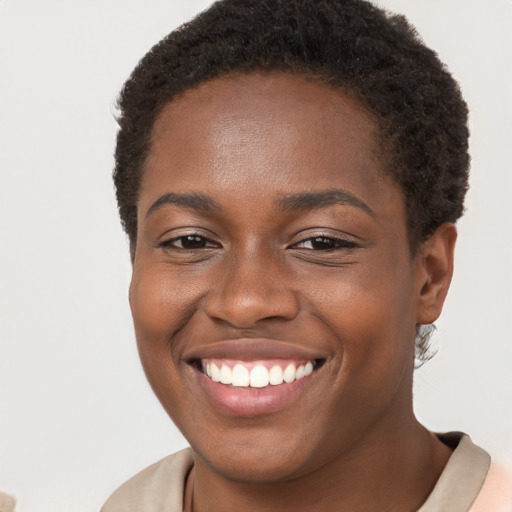 Joyful black young-adult female with short  brown hair and brown eyes