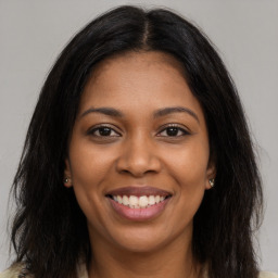 Joyful black young-adult female with long  brown hair and brown eyes