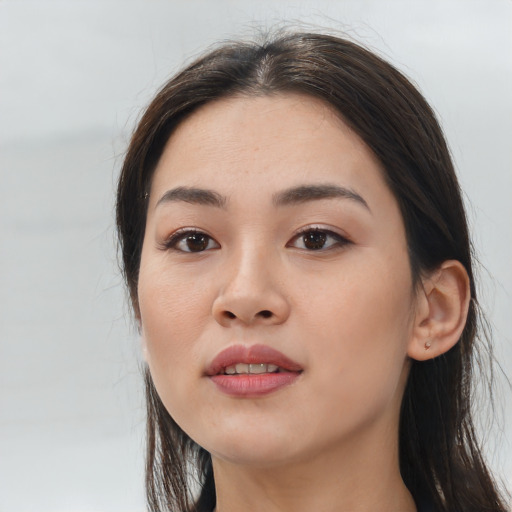 Joyful asian young-adult female with long  brown hair and brown eyes