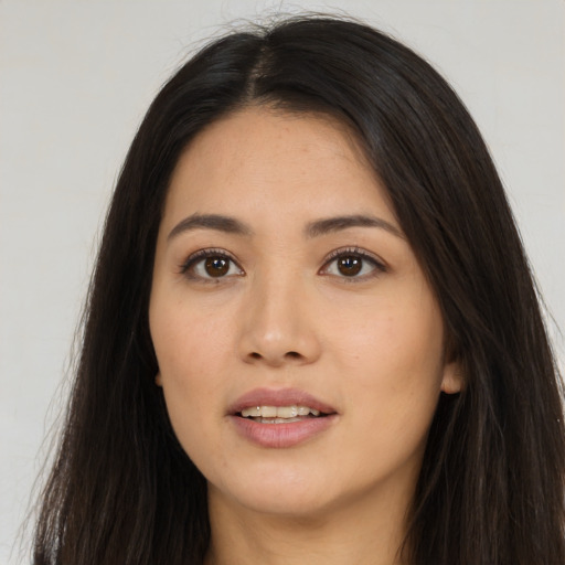 Joyful asian young-adult female with long  brown hair and brown eyes