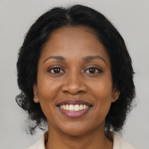 Joyful black adult female with medium  brown hair and brown eyes
