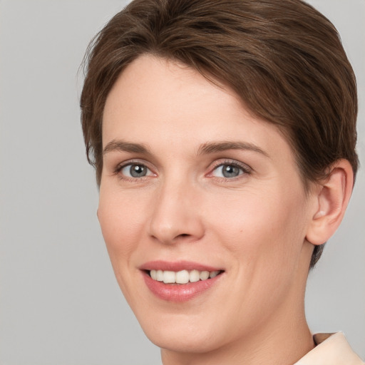 Joyful white young-adult female with short  brown hair and grey eyes