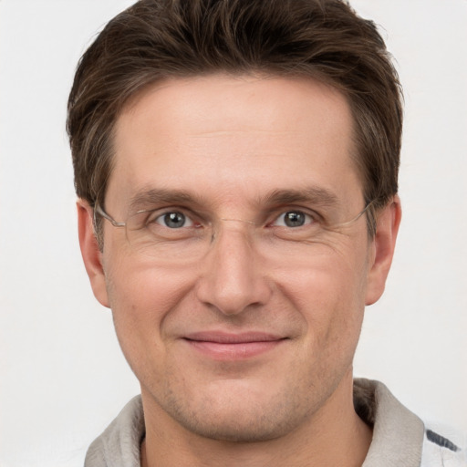 Joyful white adult male with short  brown hair and grey eyes