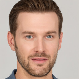 Joyful white young-adult male with short  brown hair and grey eyes