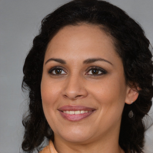 Joyful latino young-adult female with medium  brown hair and brown eyes