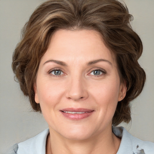 Joyful white adult female with medium  brown hair and grey eyes