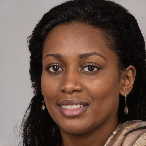 Joyful black young-adult female with long  brown hair and brown eyes