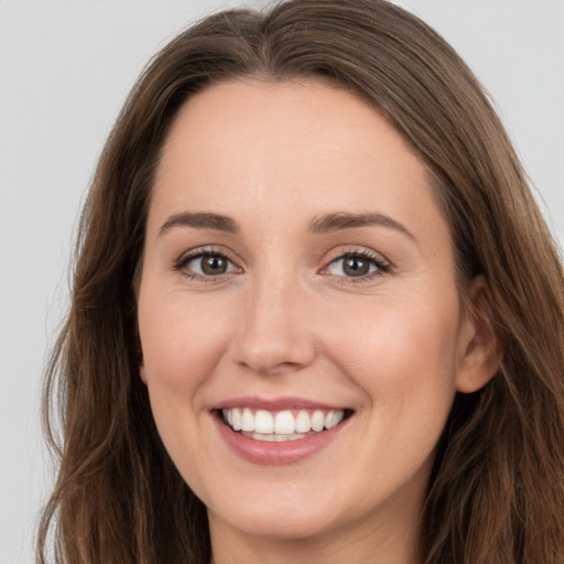 Joyful white young-adult female with long  brown hair and grey eyes