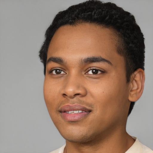 Joyful black young-adult male with short  black hair and brown eyes