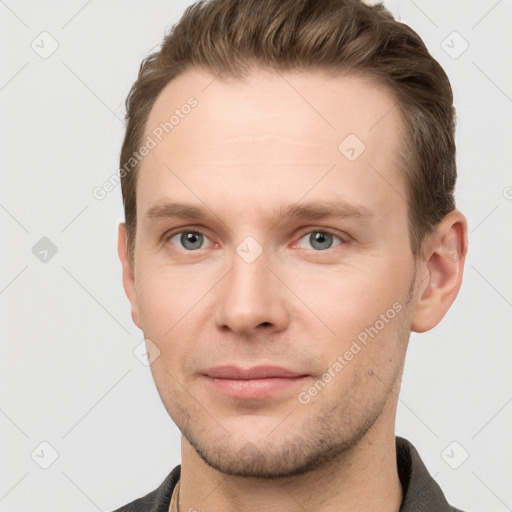 Joyful white young-adult male with short  brown hair and grey eyes