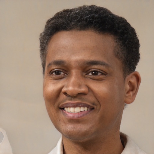 Joyful black adult male with short  brown hair and brown eyes