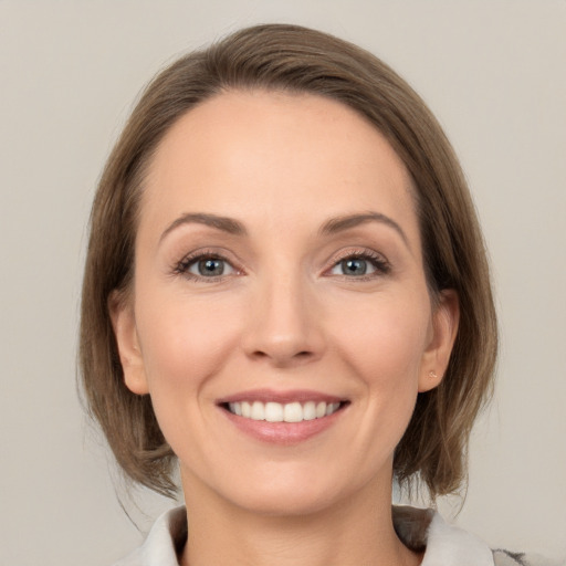 Joyful white young-adult female with medium  brown hair and grey eyes