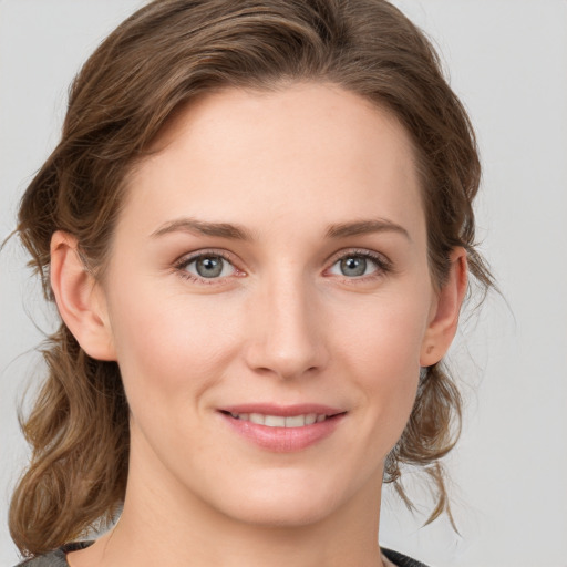 Joyful white young-adult female with medium  brown hair and grey eyes